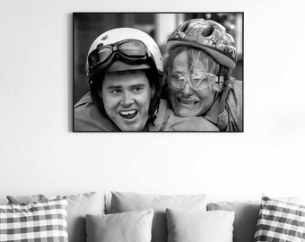 May include: Black and white photo of two people wearing helmets and goggles, smiling at the camera. The person in the front is wearing a motorcycle helmet and goggles, while the person in the back is wearing a bicycle helmet and goggles.