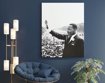 Può includere: Fotografia in bianco e nero di Martin Luther King Jr. che tiene un discorso a una grande folla. Indossa un abito e una cravatta e ha il braccio alzato in aria. La foto è stampata su tela e incorniciata.