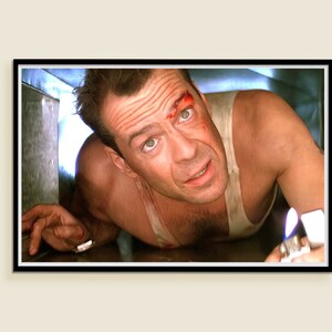 May include: A man with a bloody face and a white tank top is crawling through a small space. He is holding a lighter in his hand.