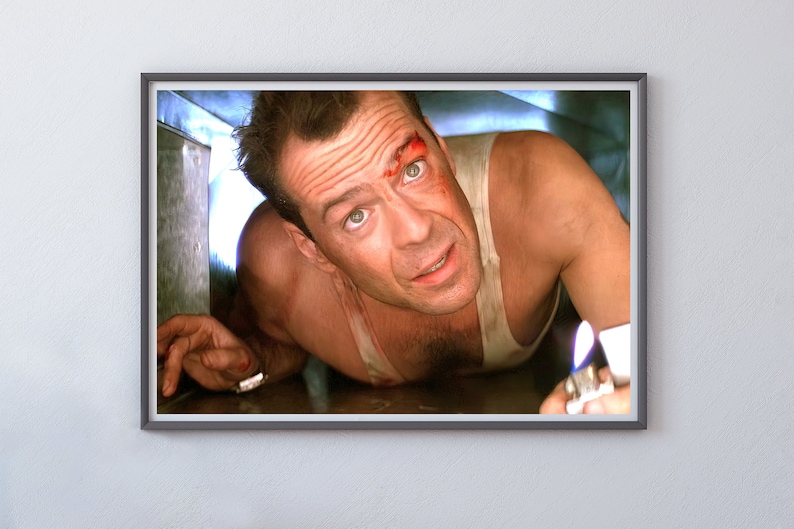 May include: A man with a bloody face crawls through a narrow space, holding a lighter with a flame. He is wearing a white tank top.