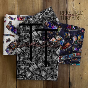 May include: Three fabric panels with a film strip pattern. The panels feature different Disney characters and a white background with gold stars. The text "TREASURED THREADS" is visible in the top right corner.