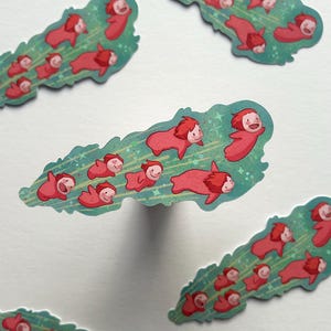 Peut inclure: Cinq autocollants fantaisistes en forme de feuille verte avec un motif d'étoiles bleu clair et blanc. Chaque autocollant présente plusieurs personnages rouges avec des visages souriants. Les autocollants sont dispersés sur un fond blanc.