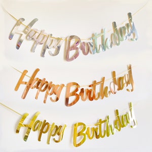 May include: Three gold foil Happy Birthday banners with different shades of gold. The top banner is silver, the middle banner is rose gold, and the bottom banner is a bright gold.