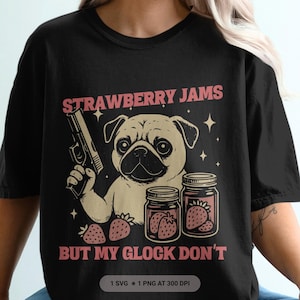 May include: Black t-shirt with a graphic of a pug holding a gun, jars of strawberry jam, and the text "STRAWBERRY JAMS BUT MY GLOCK DON'T". The design includes strawberries and star accents.