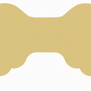 May include: A pair of wooden angel wings, painted in a light gold color. The wings are shaped like a traditional angel wing with a rounded top and a pointed bottom.