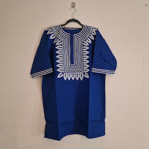 May include: A royal blue tunic with a white embroidered neckline featuring a geometric pattern.