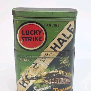 May include: Vintage Lucky Strike Half and Half tobacco tin. The tin is green with a red and white circular logo. The words "Genuine" and "Roll Cut Tobacco" are also visible.