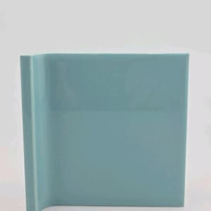 May include: A square, light blue ceramic vase with a curved side. The vase has a smooth, glossy finish and a modern, minimalist design. The vase is suitable for displaying flowers or as a decorative accent piece.