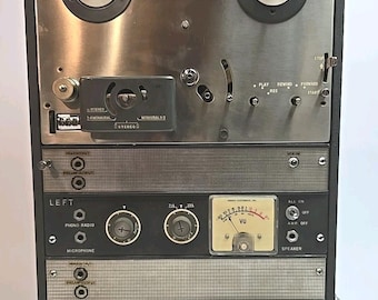 May include: Vintage reel-to-reel tape recorder with a brushed metal face and black accents. Features VU meters, control knobs, and labeled inputs for left and right channels. Includes play, rewind, and record functions.