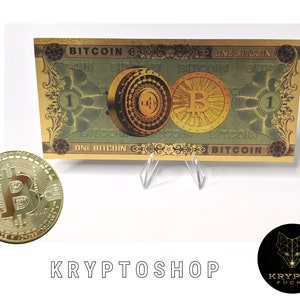 Peut inclure: Une pièce de monnaie Bitcoin dorée avec un 'B' stylisé au centre, entouré d'un motif circulaire. La pièce est sur un fond vert et or avec le texte 'ONE BITCOIN' et 'BITCOIN' imprimé dessus.