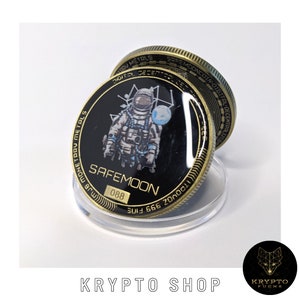 Può includere: Una moneta di metallo dorata con uno sfondo nero che presenta un astronauta con una tuta spaziale. La moneta ha il testo "SAFEMOON" e il numero "088" stampato su di essa.