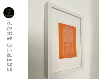 Criptoarte "Toma la pastilla naranja" en un marco blanco