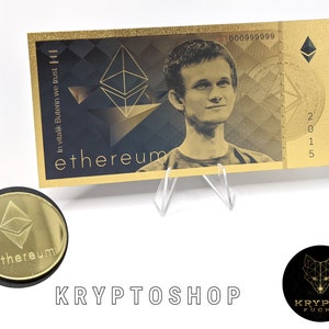 Könnte beinhalten: Ein goldfarbener Ethereum-Kryptowährungs-Schein mit einem Porträt von Vitalik Buterin, dem Schöpfer von Ethereum, und dem Text "In Vitalik Buterin we trust" und "ethereum". Der Schein hat eine Seriennummer und das Jahr 2015 aufgedruckt. Eine goldfarbene Ethereum-Münze ist ebenfalls auf dem Bild zu sehen.
