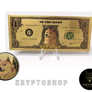 Könnte beinhalten: Eine goldfarbene Doge-Münze mit einem Shiba Inu-Hund auf der Vorderseite. Die Münze trägt den Text "currency wowmuch coin how money so crypto plz me" am Rand. Die Münze liegt auf einer weißen Oberfläche.