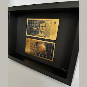 Peut inclure: Deux impressions encadrées de billets de crypto-monnaie Ethereum de couleur or. Le billet du haut présente un portrait de Vitalik Buterin, le créateur d'Ethereum, ainsi que le texte "ethereum" et "2015". Le billet du bas présente un logo Ethereum stylisé et le texte "ethereum".