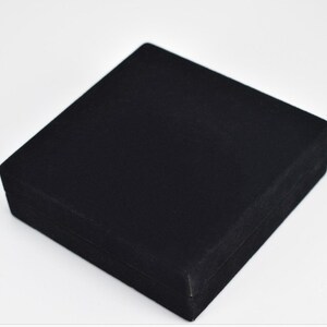 May include: A black velvet jewelry box with a hinged lid.