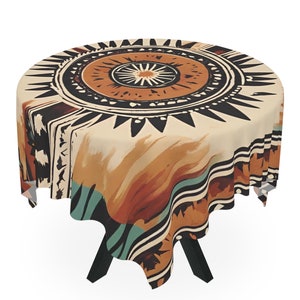 May include: Round tablecloth with a beige background and a black, brown, and teal geometric pattern. The pattern features a large circular design with a sunburst motif in the center.