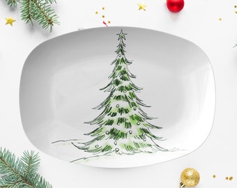 May include: White, oval serving platter with a hand-drawn green Christmas tree design. The tree is decorated with small white lights and topped with a star. A festive holiday serving dish for Christmas.