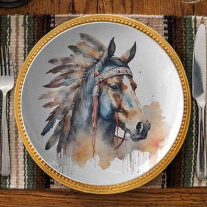 May include: A white ceramic dinner plate with a gold rim features a watercolor painting of a brown horse wearing a colorful headdress. The horse's head is turned to the side, and its eyes are closed. The background is a light blue watercolor wash.