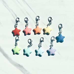 May include: A set of ten star-shaped charms in various pastel colors, each attached to a silver lobster clasp. The charms are perfect for adding a touch of whimsy to jewelry, bags, or keychains.