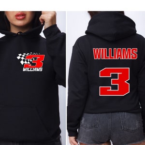 Op de afbeelding: Zwart hoodie met een rood nummer 3 en het woord "WILLIAMS" op de voor- en achterkant. Het nummer 3 is wit omrand en heeft een geruit vlagontwerp op de voorkant.