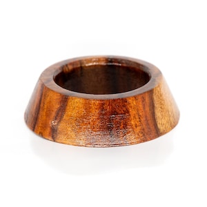 May include: A wooden ring stand with a dark brown and reddish brown wood grain pattern. The stand is shaped like a cone with a circular top.
