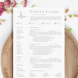 Op de afbeelding: Een medisch cv-sjabloon met de naam "Evelyn Clark". Het document staat op wit papier, met secties voor opleiding, werkervaring en vaardigheden. Het cv wordt omringd door een houten bord en roze bloemen. Afmetingen in cm.