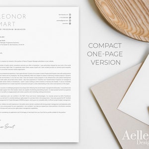 May include: A one-page resume template with the name ELEONOR SMART and title SENIOR PROGRAM MANAGER. The resume is on white paper with a minimalist design. A pen, envelopes, and a wooden tray are in the background.