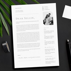 May include: A home offer letter on white paper with the text "Dear Seller," and a black and white photo of a couple. A black pen, a notepad, and a silver clip are also on the black surface. Green leaves and black and white polka dot tape are in the background.