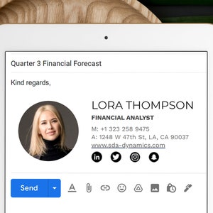 May include: A digital screen displaying a business card for Lora Thompson, Financial Analyst. The card includes contact information, social media links, and a professional headshot of Lora.