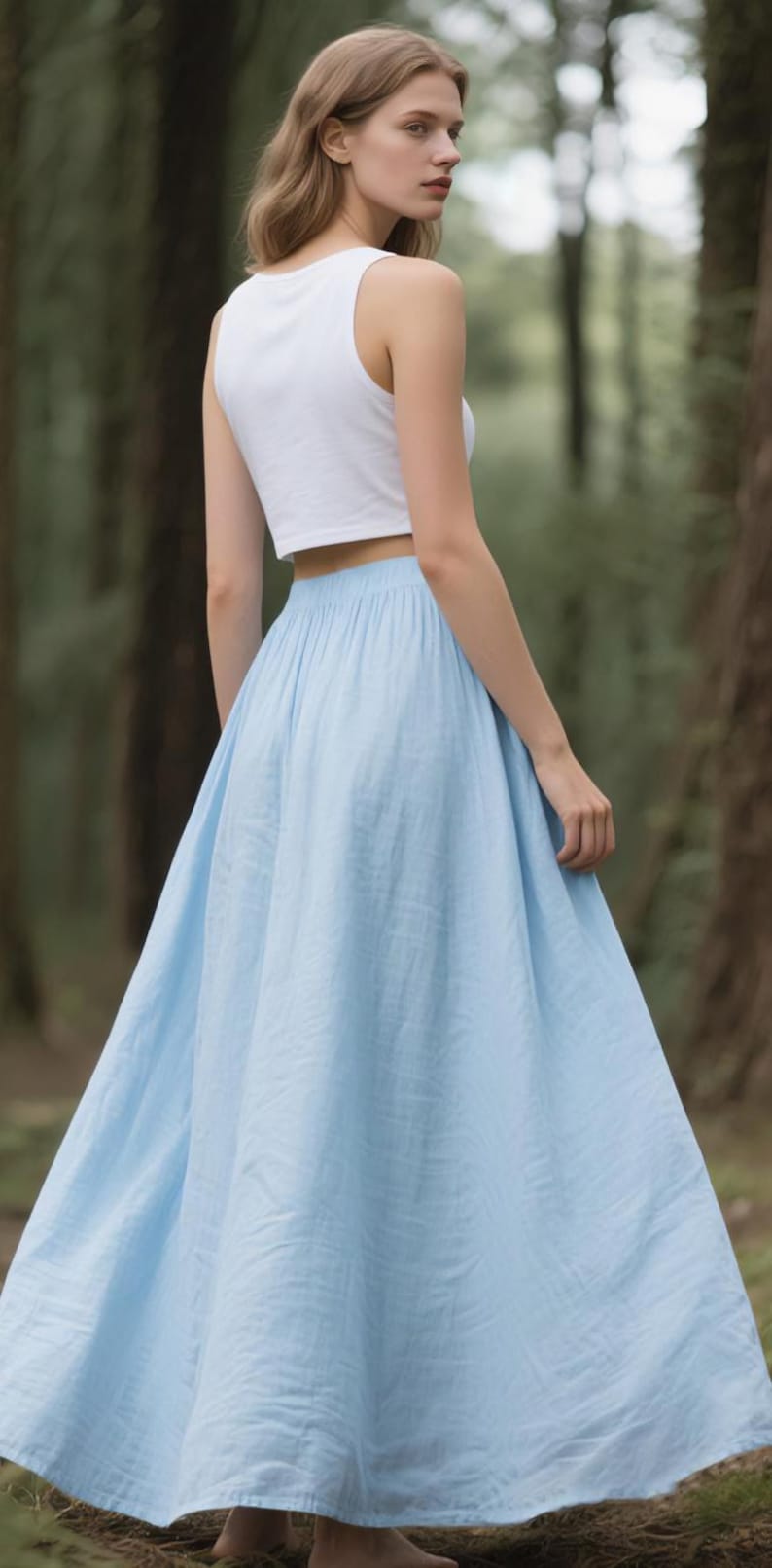 May include: A white sleeveless crop top paired with a long, light blue maxi skirt. The skirt features a gathered elastic waistband and a full, flowing silhouette that reaches the ground, while the top is a simple, fitted sleeveless design.