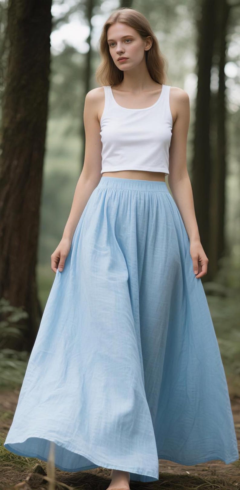 May include: A white sleeveless crop top paired with a light blue floor-length maxi skirt. The top features a scoop neckline and a fitted silhouette, while the skirt has a gathered elastic waistband and a full, flowing cut that reaches the ground.