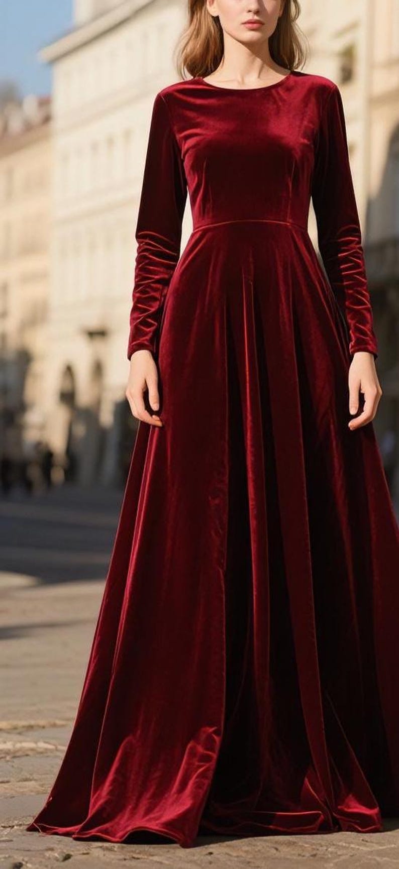 May include: A long, burgundy velvet dress with long sleeves. The dress has a fitted bodice and a flowing skirt. The sleeves are ruched at the wrists. The dress is suitable for formal occasions.
