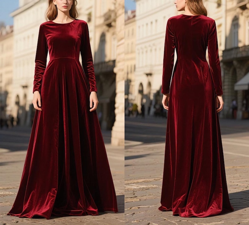 May include: A long, burgundy velvet dress with a round neckline and long sleeves. The dress has a flowing A-line skirt and is floor-length. The fabric has a soft sheen, and the dress appears to be well-tailored. The background shows a city street.