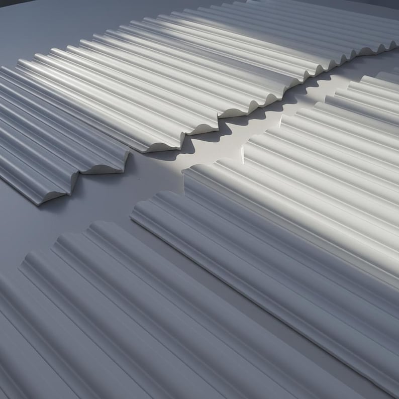 White decorative molding pieces with a fluted design. The pieces are arranged in a pattern, with shadows creating depth. The molding has a scalloped edge and is likely for interior design or architectural use.