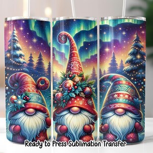 May include: Three colorful tumblers with a Christmas gnome design. Each tumbler features a gnome with a long white beard and a festive hat. The background shows a starry night sky and Christmas trees. Text at the bottom reads "Ready to Press Sublimation Transfer."