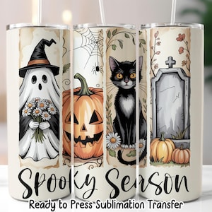 May include: A Halloween-themed tumbler featuring a ghost in a witch hat, a jack-o'-lantern, a black cat, and a tombstone. The words "Spooky Season" are displayed in a decorative font. The tumbler is white with a sublimation transfer design.
