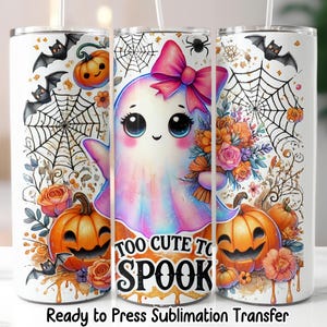 May include: White Halloween tumbler featuring a cute ghost with a pink bow, holding flowers, and surrounded by pumpkins, bats, and spiderwebs. Text reads "Too Cute to Spook".