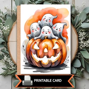 K&ouml;nnte beinhalten: Eine Halloween-Karte zum Ausdrucken mit einem l&auml;chelnden K&uuml;rbis und vier freundlichen Geistern. Die Karte hat ein orange-braunes Farbschema mit dem Text "PRINTABLE CARD" unten.