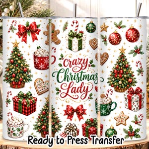 May include: A white cylindrical tumbler featuring a festive Christmas pattern with decorated pine trees, red and green gift boxes, gingerbread cookies, candy canes, and mugs of cocoa. The text Crazy Christmas Lady is printed in red and green.
