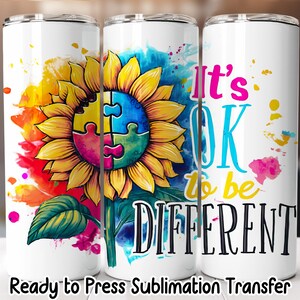 May include: Three white insulated tumblers with a sunflower design. The sunflower has puzzle piece petals and is surrounded by colorful watercolor splashes. Text on the tumblers reads "It's OK to be DIFFERENT."