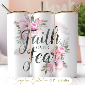 May include: White stainless steel tumbler with a floral design in pink and green, and the words "Faith Over Fear" in black script. The tumbler has a gold-colored rim and a straw.