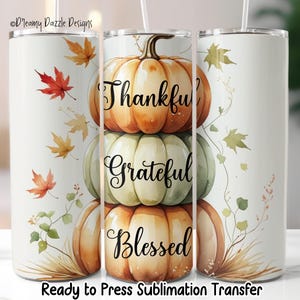 May include: A white tumbler with a fall theme. It features a stack of pumpkins in shades of orange and green, with the words "Thankful, Grateful, Blessed" in black script. Autumn leaves and foliage decorate the sides. The text "Ready to Press Sublimation Transfer" is at the bottom.