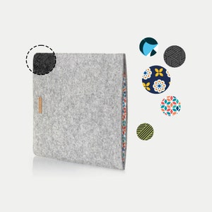 May include: A grey felt laptop sleeve with a colourful patterned lining. The sleeve has a flap that closes with a magnetic closure. The sleeve is made of a soft, durable material and is perfect for protecting your laptop from scratches and bumps.