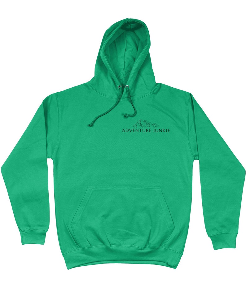 May include: A bright green hoodie with a drawstring hood and a kangaroo pocket. The hoodie features a black graphic of mountains and the text "ADVENTURE JUNKIE" printed on the chest. The sweatshirt is made of a soft material.