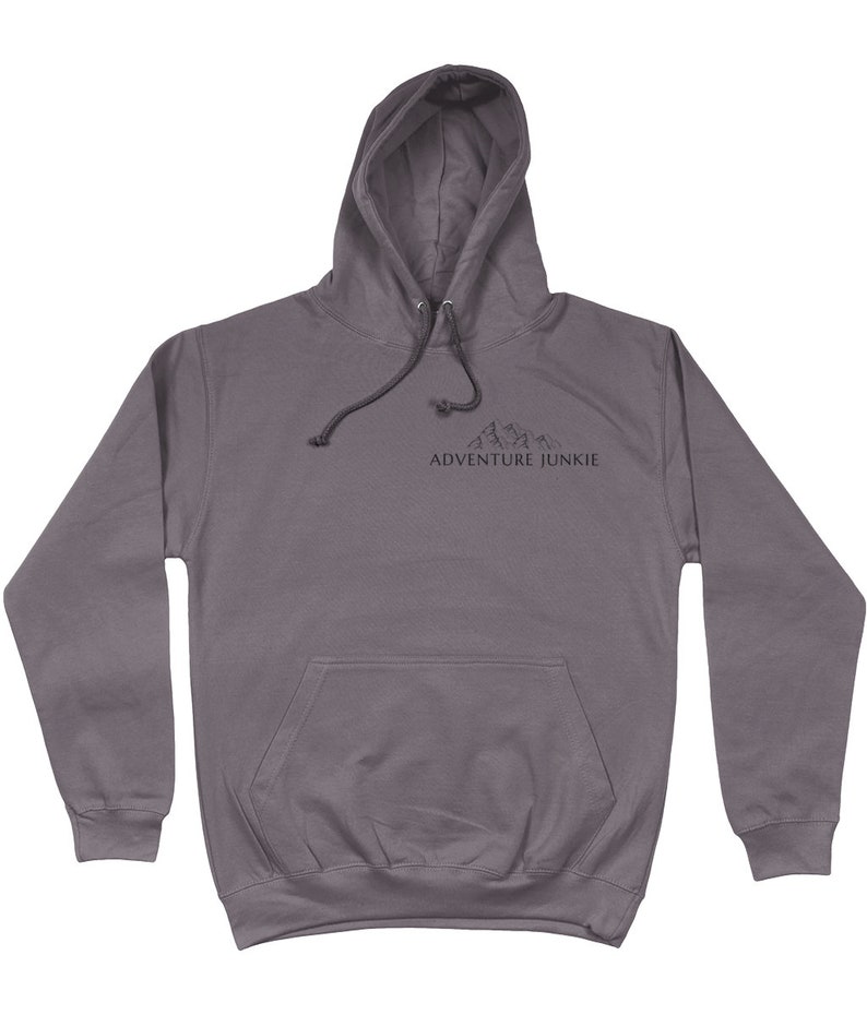 May include: A gray hooded sweatshirt with a front pocket and drawstring. The text "ADVENTURE JUNKIE" is printed below a mountain graphic on the chest. The hoodie is made of a soft material.