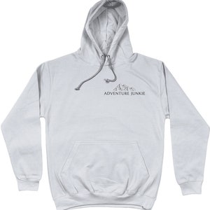 May include: A light gray hoodie with a drawstring hood and a front pocket. The hoodie features a small mountain graphic and the text "ADVENTURE JUNKIE" printed in dark gray. The hoodie is made of a soft material.