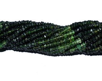 May include: A strand of dark green gemstone beads, each bead is faceted and has a slightly irregular shape.