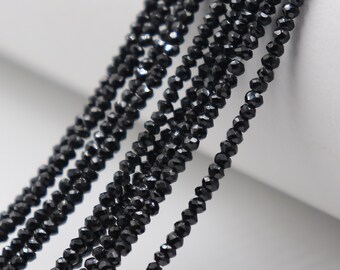 May include: A strand of black faceted beads, likely made of glass or crystal, for jewelry making.