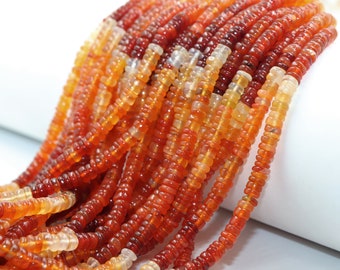 May include: Close-up of strands of orange and red gemstone beads. The beads are small, flat, and disc-shaped, with a polished surface. The color gradient ranges from light orange to deep red.